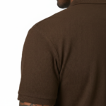 Man wearing a dark brown polo t-shirt with a small white V logo on the left chest holding a coffee cup.