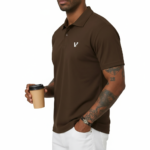 Man wearing a dark brown polo t-shirt with a small white V logo on the left chest holding a coffee cup.