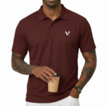 Man wearing a dark brown polo t-shirt with a small white V logo on the left chest holding a coffee cup.