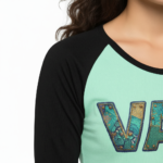 Women's VALE patchwork raglan shirt made of breathable cotton, 3/4 sleeves, featuring colorful textured letter patches on a baseball-style tee.