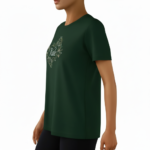 A woman wearing a premium breathable cotton t-shirt featuring the "Vale" brand logo in white script surrounded by a floral wreath with pink roses. Available in forest green, mustard orange, and cream beige colors.