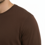 Back view of a man wearing a VALE graphic long-sleeve cotton shirt featuring a vintage gate design and Roman numerals MCMXCIX.