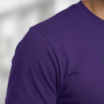 A man wearing a slim-fit 100% cotton t-shirt with a vertical 'VALE' graphic in a vibrant purple, gold, and blue metallic texture.