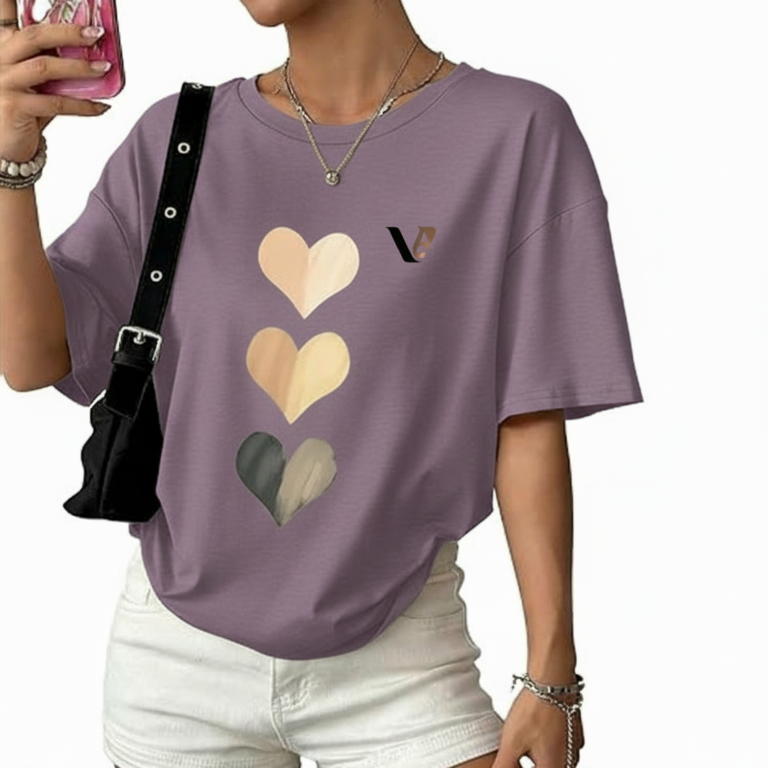 Front view of a woman wearing an oversized breathable cotton t-shirt with a triple heart graphic design and a small "V" logo, styled with white denim shorts and a black shoulder bag.