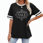 A person wearing a breathable cotton VALE graphic t-shirt with varsity stripes on sleeves, available in black, brown, and orange.