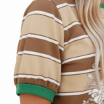 Women's breathable cotton striped t-shirt with floral rose print and green contrast trim, styled with denim jeans.