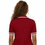 A high-quality studio shot of a model wearing a VALE brand breathable cotton polo shirt featuring white-tipped collars and a detailed gold floral celestial embroidery on the chest.