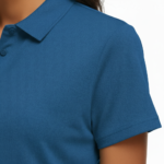 Close-up of a woman wearing a breathable pique cotton polo shirt featuring a "VALE" floral and crescent moon embroidery on the chest, available in green, blue, and orange.