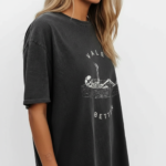 Oversized vintage washed cotton t-shirt featuring a skeleton lying in a coffin with "VALE BETTER" text, available in charcoal black, maroon burgundy, and slate gray.
