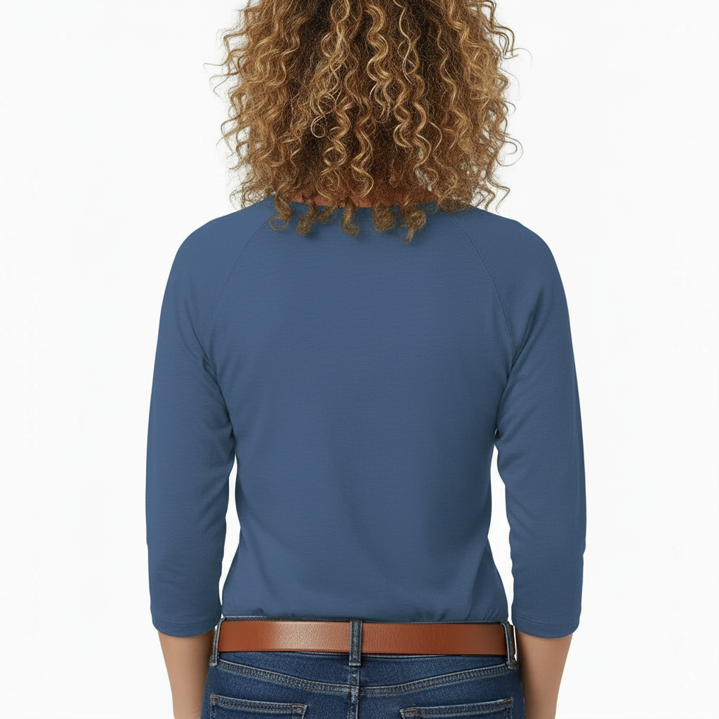 A woman wearing a VALE brand 3/4 sleeve raglan shirt made of breathable cotton, featuring a large, ornate butterfly embroidery on the chest in gold and light blue.