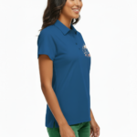 Close-up of a woman wearing a breathable pique cotton polo shirt featuring a "VALE" floral and crescent moon embroidery on the chest, available in green, blue, and orange.