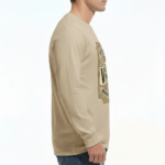 A man wearing a VALE Traveler’s Goods long-sleeve cotton shirt featuring a vintage-style gold and cream graphic label that says "Bound for Adventure" on the chest.