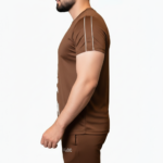 Full-body view of a man wearing the VALE brand breathable cotton activewear set, featuring a vertical logo t-shirt and matching side-striped joggers on a white background.