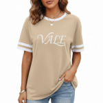 Woman wearing VALE graphic print ringer t-shirt in maroon, grey, and beige colors with varsity sleeve stripes.