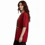 Front view of a female model wearing a VALE Nature's Legacy oversized cotton t-shirt featuring a phoenix and floral graphic design in Maroon, Blue, and White.