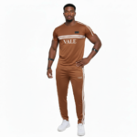 Man wearing VALE brand breathable cotton tracksuit with short-sleeve t-shirt and matching joggers in earth tones.