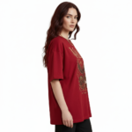 Front view of a female model wearing a VALE Nature's Legacy oversized cotton t-shirt featuring a phoenix and floral graphic design in Maroon, Blue, and White.