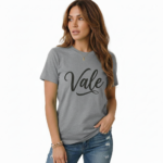 Woman wearing a "Vale" script graphic t-shirt made of breathable cotton, paired with distressed denim jeans, available in Slate Blue, Heather Grey, and Mint Green.