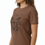 Woman wearing a Vale brand butterfly graphic t-shirt in brown, white, and maroon, featuring a vintage botanical butterfly design on 100% breathable cotton fabric.