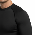 Back and front view of a man wearing a VALE brand compression suit featuring a manual transmission gear shifter graphic on the back of the long-sleeve shirt and matching leggings, shown in black, orange, and grey colors.