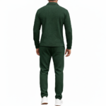 Front view of a professional male model wearing a VALE brand textured cotton tracksuit featuring a quarter-zip polo sweatshirt and matching joggers with minimalist graphic logos on the chest and thigh.