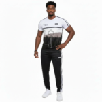 Man wearing a VALE brand breathable cotton tracksuit featuring a forest landscape and key graphic print on the shirt with matching striped track pants.