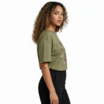 Young woman wearing a "Vale Girl" breathable cotton t-shirt with a vintage floral and hummingbird graphic design, available in Olive Green, Royal Blue, and Red.