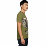 Front view of a man wearing a VALE brand steampunk graphic t-shirt featuring internal watch gears and cogs design, 100% cotton breathable fabric, available in Olive, Grey, and White.