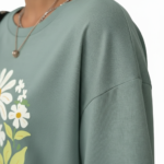 Women's oversized breathable cotton t-shirt featuring a vintage daisy floral print in sage green, brown, and red colors.