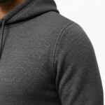 Man wearing a textured breathable cotton tracksuit with a vintage traveler's badge on the back, available in Obsidian Navy, Forest Green, and Heather Charcoal.