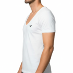 Close-up of a model wearing a premium men's deep V-neck cotton t-shirt in cream with a small black embroidered V-logo on the left chest.