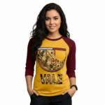 Woman wearing a VALE brand raglan shirt featuring a detailed gold mechanical watch gear graphic and steampunk-style typography on breathable cotton fabric.
