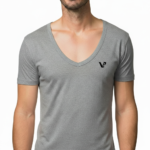 Close-up of a model wearing a premium men's deep V-neck cotton t-shirt in cream with a small black embroidered V-logo on the left chest.