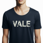 Close-up of a man wearing a burnt orange VALE distressed graphic t-shirt with white block lettering.