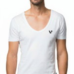 Close-up of a model wearing a premium men's deep V-neck cotton t-shirt in cream with a small black embroidered V-logo on the left chest.