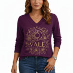 Women's long-sleeve V-neck cotton shirt featuring a gold VALE celestial sun, moon, and floral graphic design.