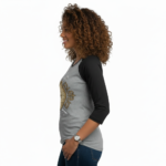 Woman wearing a breathable cotton raglan 3/4 sleeve shirt featuring a vintage nautical compass "VALE" graphic design, available in Grey/Black, White/Grey, and Olive/Black colorways.