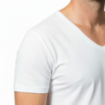 Close-up of a model wearing a premium men's deep V-neck cotton t-shirt in cream with a small black embroidered V-logo on the left chest.