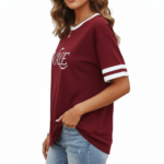 Woman wearing VALE graphic print ringer t-shirt in maroon, grey, and beige colors with varsity sleeve stripes.