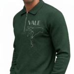Front view of a professional male model wearing a VALE brand textured cotton tracksuit featuring a quarter-zip polo sweatshirt and matching joggers with minimalist graphic logos on the chest and thigh.
