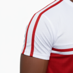 Man wearing VALE brand two-tone cotton tracksuit set in orange, red, and green with white accents and "key in hand" logo.