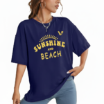 Woman wearing a breathable cotton oversized t-shirt with "Sunshine and Beach" yellow graphic print, available in navy blue, maroon, and red.
