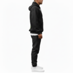 A man wearing a premium breathable cotton tracksuit featuring a colorful watercolor tree graphic with "VALE" text on the back, available in Black, Burgundy, and Sand.