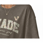 Flat lay and model view of women's oversized "MADE Pure Joy" floral graphic t-shirt in dusty brown, slate blue, and sage green.