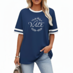 Women's oversized breathable cotton varsity t-shirt featuring a white VALE floral wreath graphic and striped sleeves, shown in Navy, Green, and Red.