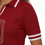 A high-quality studio shot of a model wearing a VALE brand breathable cotton polo shirt featuring white-tipped collars and a detailed gold floral celestial embroidery on the chest.