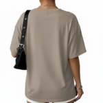 Front view of a woman wearing an oversized breathable cotton t-shirt with a triple heart graphic design and a small "V" logo, styled with white denim shorts and a black shoulder bag.