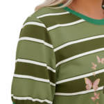 A smiling model wearing a breathable VALE brand cotton t-shirt with horizontal stripes, featuring a central butterfly graphic design and puff sleeves, paired with light-wash distressed denim jeans against a clean white background.