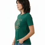 Woman wearing a Vale Authentic Style limited edition graphic t-shirt featuring rose gold butterfly and floral art on forest green, white, and burgundy cotton fabric.