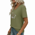 A woman wearing a breathable cotton V-neck t-shirt with a floral "Vale" graphic design, available in orange, khaki, and olive green colors.